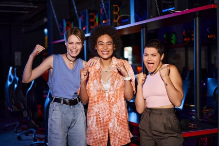 Frauen in modischen Kleidern teilen einen freudigen Moment, als sie sich im Cybersport-Club freuen, Freunde