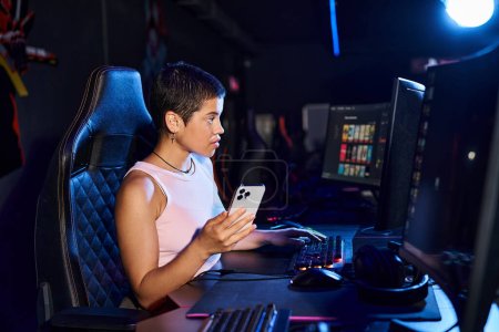 Eine Frau in legerer Kleidung sitzt gespannt an ihrem Schreibtisch, den Blick fest auf den Computerbildschirm gerichtet.