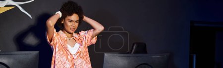 frustrated african american woman with curly hair looking at computer and stressing out, banner