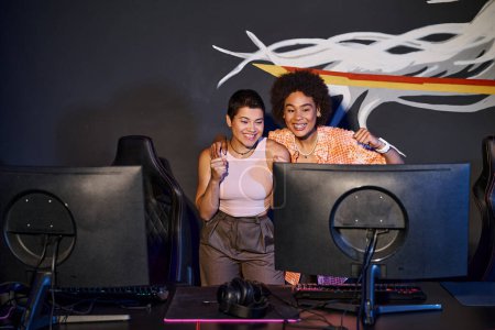 multikulturelle und glückliche Freunde, die auf den Computermonitor schauen und den Sieg feiern, Cybersport