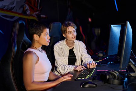 Téléchargez les photos : Deux femmes se sont concentrées sur une session de jeux cybersport, les jeunes joueurs réfléchissant sur la stratégie de jeu - en image libre de droit