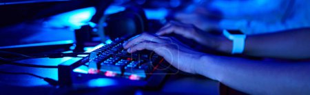 cropped banner of female hands, young gamer using computer keyboard while playing game, cybersport