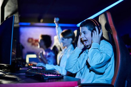 Fokus auf fröhliche junge Frau gewinnt Spiel neben verschiedenen Freundinnen, Cybersport-Spieler