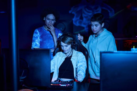 young diverse female gamers looking at computer monitor while thinking on game strategy, cybersport