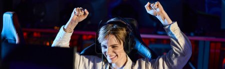 cheerful female gamer rejoicing and looking at monitor after winning game, cybersport banner