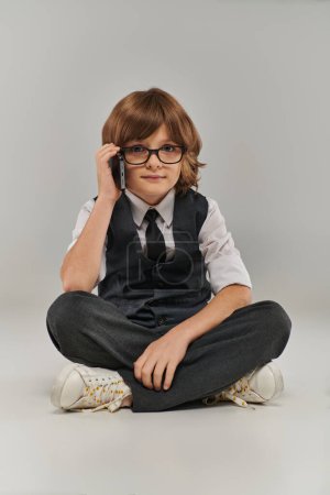 Ein kleiner Junge strahlt Zuversicht und Professionalität aus, wenn er mit seinem zukünftigen Geschäftsmann telefoniert