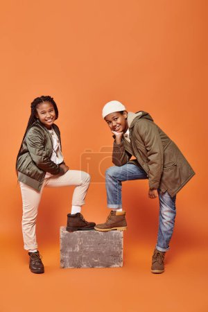 Téléchargez les photos : Joyeux préadolescent afro-américain garçon et fille posant ensemble et souriant heureux à la caméra - en image libre de droit