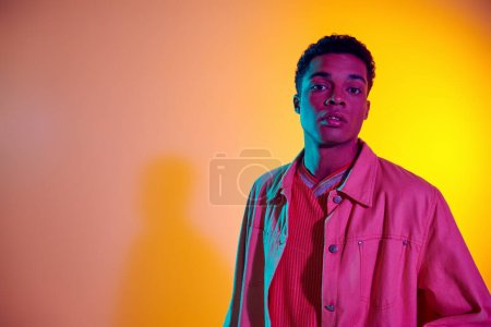 young african american man posing in trendy and casual clothing with vibrant gradient background