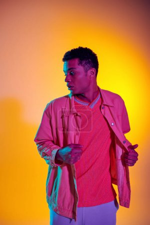 young african american man posing in stylish and casual clothing with vibrant gradient background