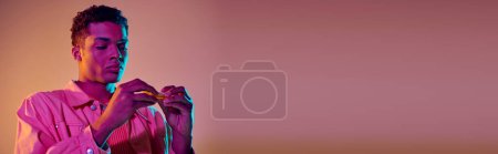 Téléchargez les photos : Afro-américain préparant e-cigarette sur fond vibrant avec éclairage bleu néon, bannière - en image libre de droit
