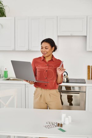 dietista afroamericano feliz dando consulta en línea en el ordenador portátil y recomendando medicamentos