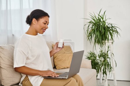 african american nutritionist with supplements giving dietary advice via laptop in living room