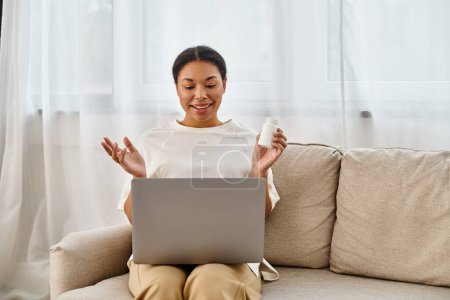joyful african american nutritionist with supplements giving dietary tip via laptop in living room