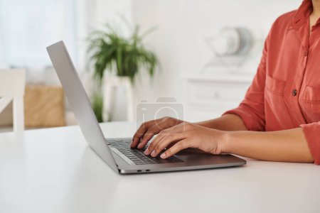 geschnittenes Foto einer afrikanisch-amerikanischen Diätassistentin mit ihrem Laptop, während sie von zu Hause aus tippt und arbeitet
