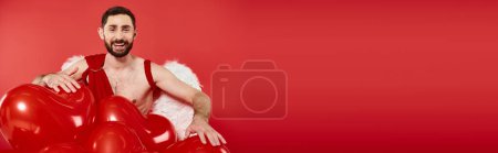 cheerful bearded cupid man near Saint Valentines day balloons on red, banner with copy space