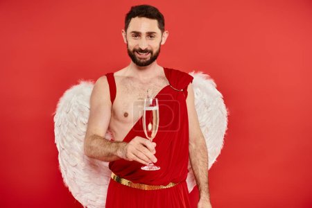 fröhlicher bärtiger Mann in Amor-Kostüm und Flügeln, der mit Champagner auf den Valentinstag anstößt
