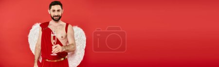 smiling bearded cupid man with champagne glass looking at camera on red, Saint Valentines, banner