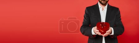 Photo for Cropped view of wealthy elegant man with st valentines day present in heart-shaped gift box, banner - Royalty Free Image