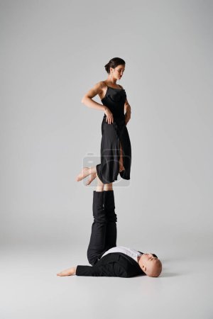 duo athlétique, couple d'acrobates jouant l'équilibre dans un décor de studio avec fond gris