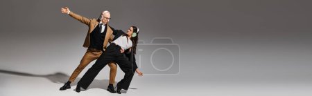 Téléchargez les photos : Bannière d'acrobates dans des écouteurs sans fil dansant dans un style de pause de bureau, mains tendues - en image libre de droit