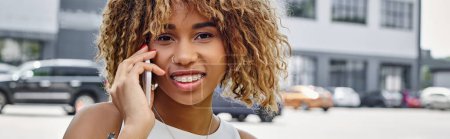 Photo for Banner of happy radiant curly-haired black woman having phone call in urban setting, smartphone - Royalty Free Image