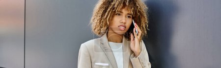 Photo for Confident african american businesswoman with curly hair talking on smartphone, banner - Royalty Free Image