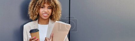 professional headshot banner, happy african american woman with coffee and folder standing by wall