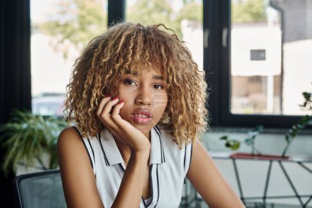 portrait de jeune femme d'affaires afro-américaine regardant la caméra au bureau, prise de vue professionnelle