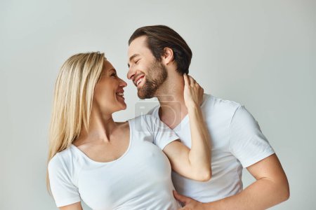 A man and a woman are smiling warmly at each other in a moment filled with romance and connection.