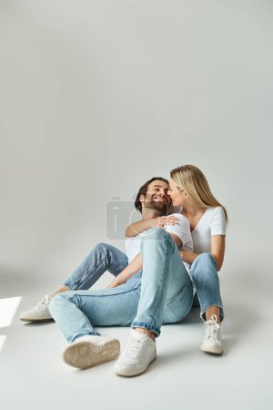 Photo for A man and a woman seated on the ground, sharing a tender moment of intimacy and connection - Royalty Free Image
