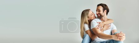 Téléchargez les photos : Un moment passionné entre un homme et une femme alors qu'ils se tiennent fermement l'un l'autre dans une étreinte aimante, une bannière - en image libre de droit