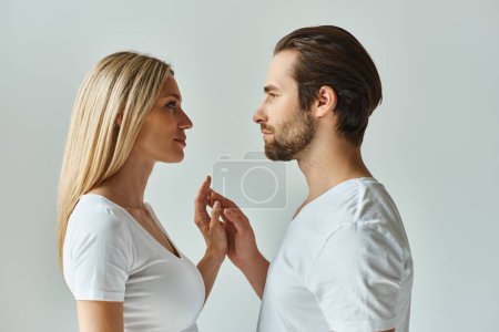 A man and a woman stand face to face, their eyes locked in a moment of intense connection and romantic tension.
