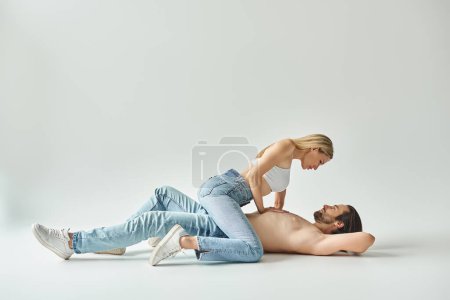 Foto de Un hombre y una mujer, encarnando el romance, tendidos uno al lado del otro en el suelo, sus cuerpos entrelazados en un apasionado abrazo. - Imagen libre de derechos