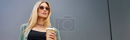 Photo for A woman, filled with warmth, holds a cup of coffee in her hand, embodying comfort and tranquility. - Royalty Free Image