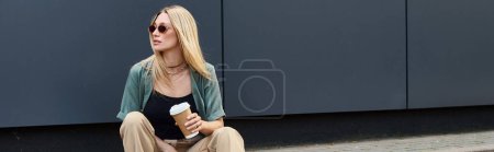 Une femme assise sur le sol, savourant une tasse de café dans un moment serein à l'extérieur.