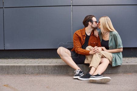 Foto de Una escena romántica de una pareja sexy sentada en el suelo, compartiendo un beso apasionado. - Imagen libre de derechos