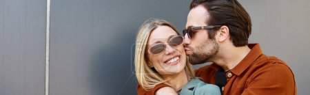 Téléchargez les photos : Un homme et une femme qui partagent un baiser romantique devant un mur recouvert de graffitis dans un moment intime de connexion. - en image libre de droit