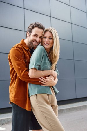 couple passionately hugging outside a modern building, exuding romance and intimacy.
