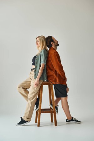 Photo for A sensual and romantic moment captured as a man and woman sit closely together on a stool - Royalty Free Image