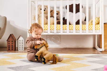niedliche Kleinkind Junge sitzt auf dem Boden und spielt mit Spielzeugpferd in der Nähe Krippe in gemütlichen Kinderzimmer