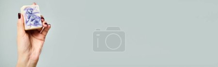 Téléchargez les photos : Jeune femme inconnue avec barre de maintien vernis à ongles de savon rayé sur fond gris, bannière - en image libre de droit