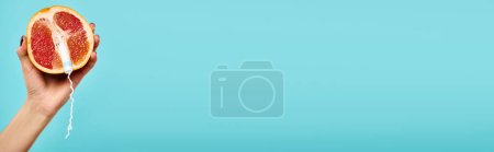 Téléchargez les photos : Objet photo de pamplemousse frais avec tampon en main de femme inconnue sur fond bleu, bannière - en image libre de droit
