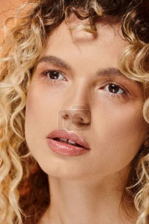 close up portrait of curly woman with natural makeup and perfect skin looking away in studio