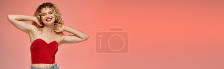 Téléchargez les photos : Femme aux lèvres rouges et aux cheveux bouclés posant en haut rouge avec les yeux fermés sur rose et jaune, bannière - en image libre de droit