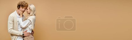 Téléchargez les photos : Vue latérale du jeune couple élégant embrassant face à face avec les yeux fermés sur beige, bannière horizontale - en image libre de droit