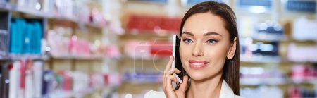 good looking jolly customer in elegant attire talking by phone while in cosmetics store, banner