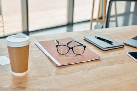 Photo for Modern office, with a wooden table a notebook and a cup of coffee. - Royalty Free Image