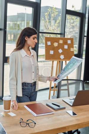 Una mujer de negocios de pie en una oficina moderna, centrada en sus gráficos