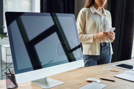 Una mujer de negocios se encuentra en una oficina moderna, examinando los datos en una pantalla de computadora vinculada a un concepto de franquicia.