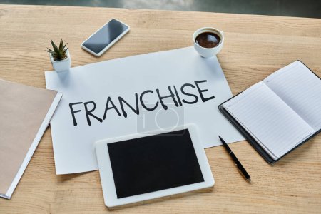 A modern office setting with a table displaying a sign that says franchise.